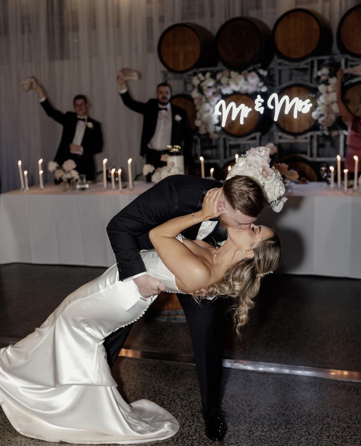 Couple sharing a romantic dip kiss during their first dance, symbolizing their unique connection and love.